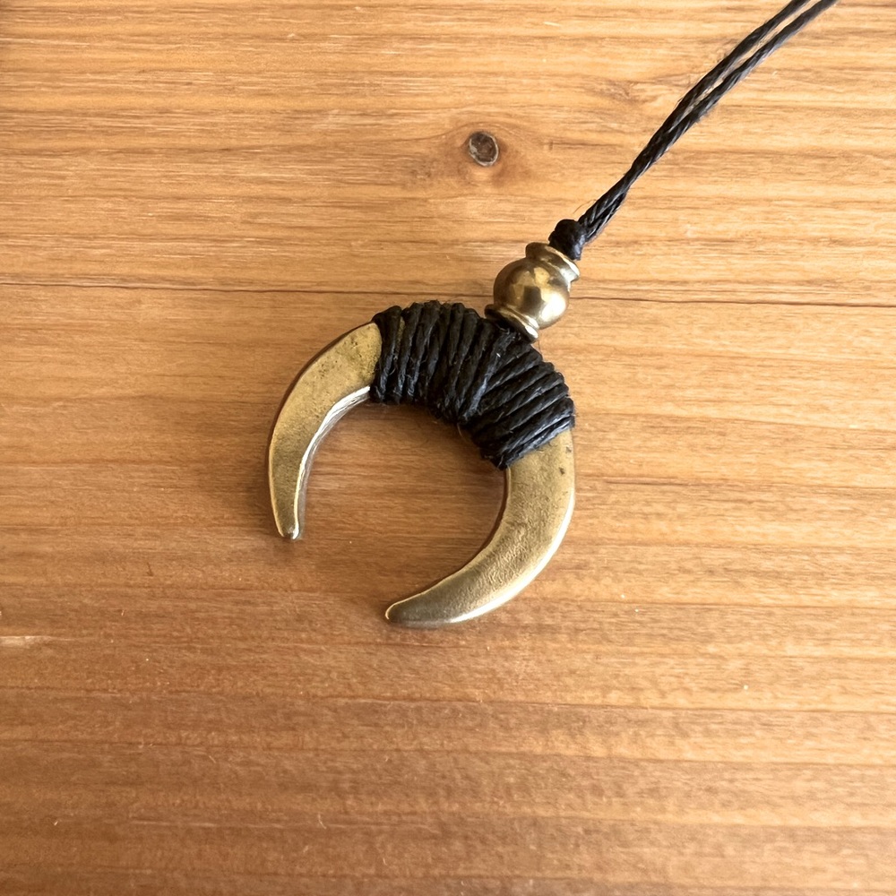 Brass moon shape pendant necklace wrapped with black wrapped linen. NWOT